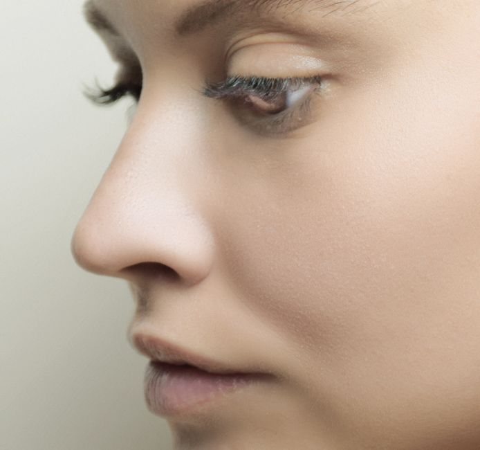 Detailed side profile of a woman's face with flawless skin and subtle makeup.