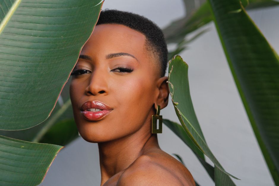 Beautiful portrait of a woman with natural makeup surrounded by foliage.