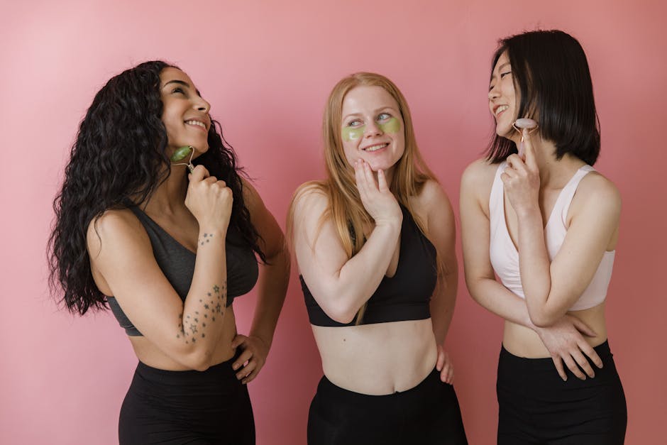 Three diverse women using jade rollers and face masks, enjoying a skincare routine.
