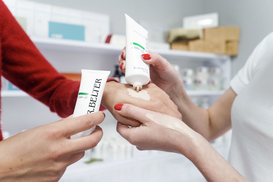 Close-up of hands applying skincare cream in a modern cosmetics environment. Perfect for beauty and skincare products.