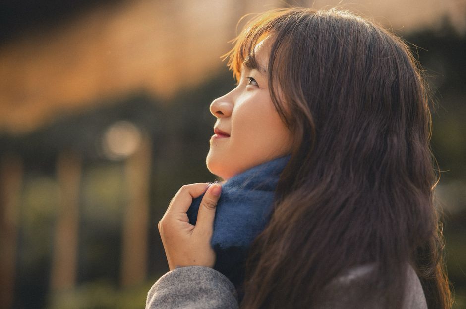 Side profile of woman looking content with natural lighting outdoors.