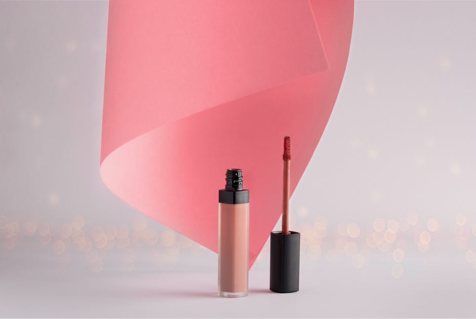 Stylish lipstick with a pink swirl backdrop, ideal for beauty and cosmetics themes.