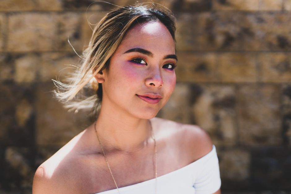 Glamorous portrait of an Asian woman against a textured wall in Los Angeles.