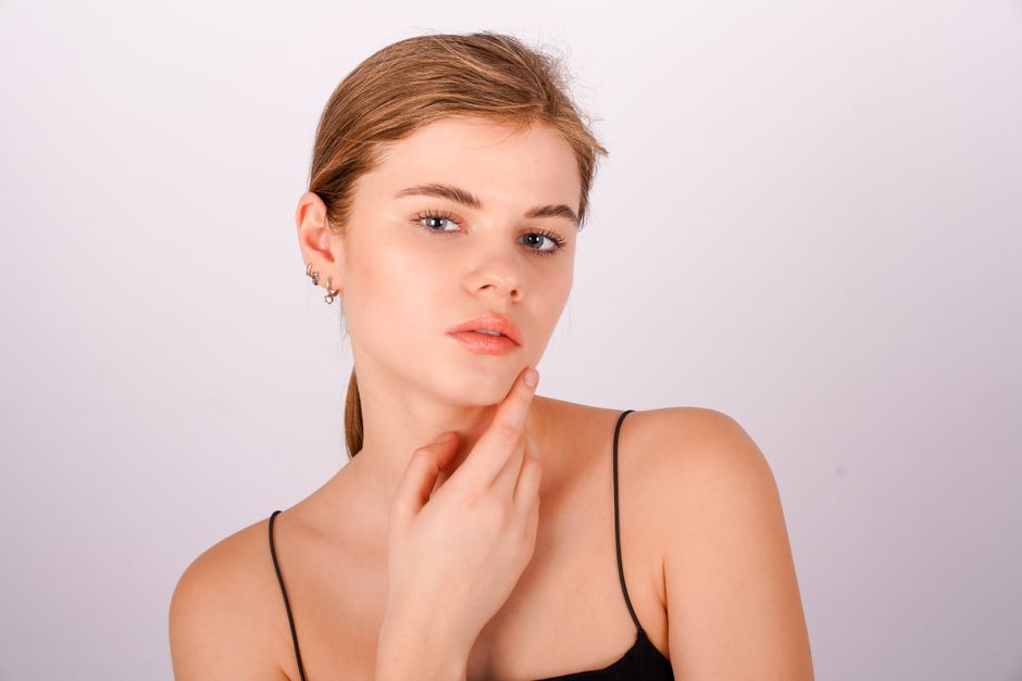 Elegant portrait of a young woman posing thoughtfully in a studio.