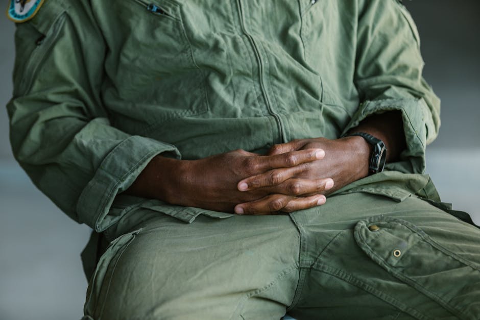 A close-up view of crossed hands on a military uniform conveying calm and respect.