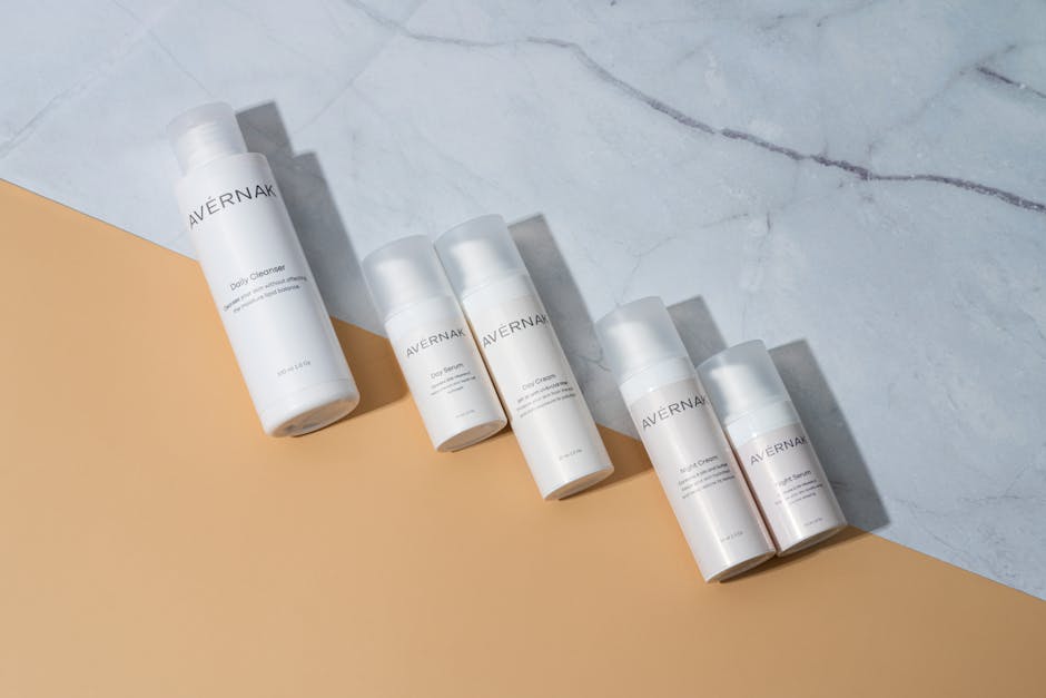 Aesthetic display of skincare bottles on a marble and beige backdrop, showcasing minimalist beauty.