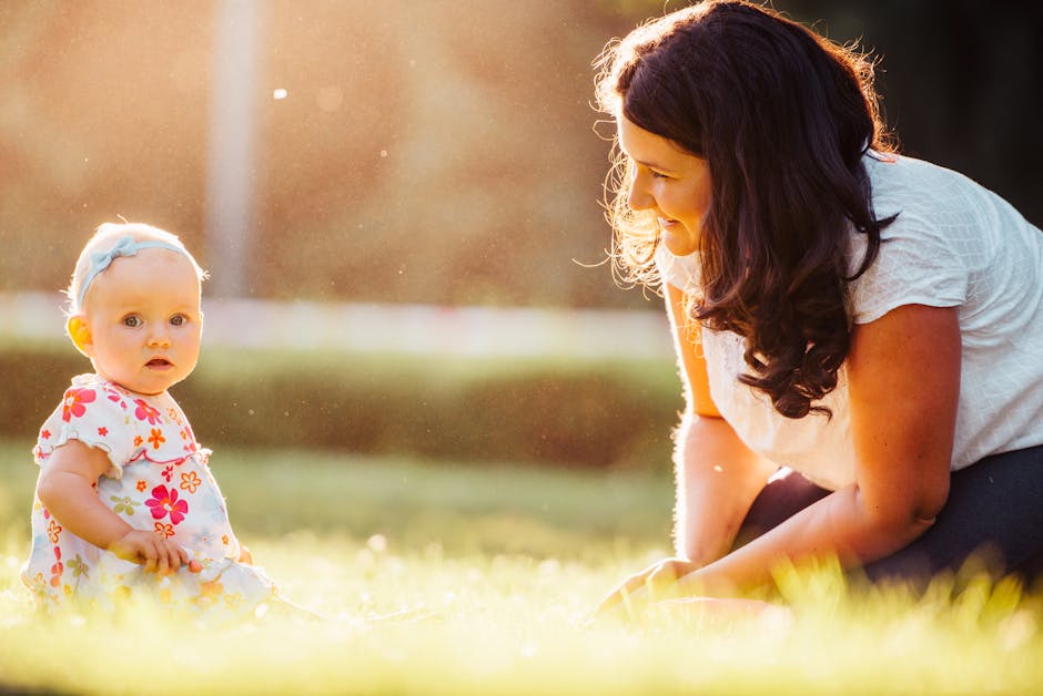 A joyful moment between a mother and baby in sunlit outdoors, showcasing love and warmth.